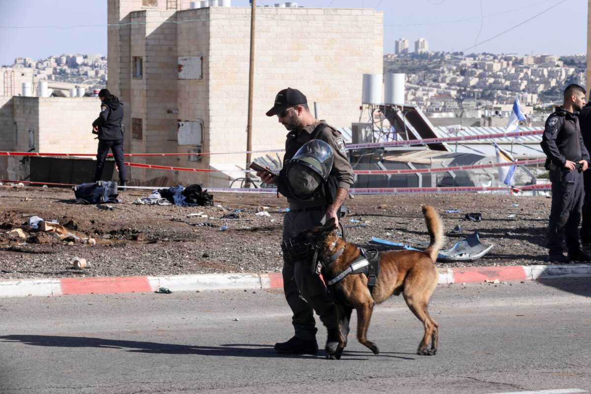 Israeli border police officer walks with his dog as they work at the scene where a suspected ramming attack took place in Jerusalem, February 10, 2023. REUTERS