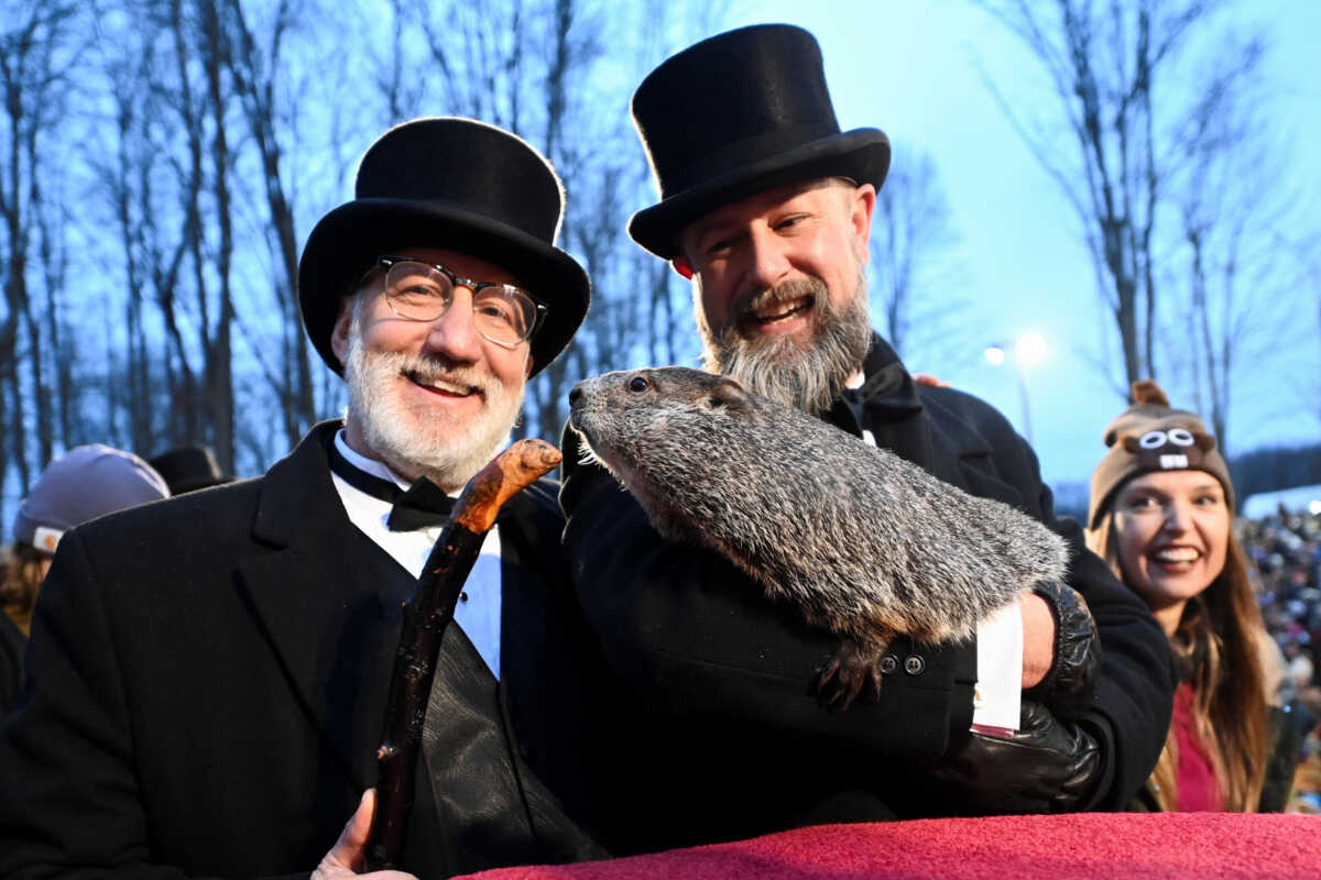 Groundhog Club President Tom Dunkel and AJ Dereume holding Punxsutawney Phil pose for a photograph during the Groundhog Day Festivities, at Gobbler's Knob in Punxsutawney, Pennsylvania, U.S., February 2, 2024. REUTERS